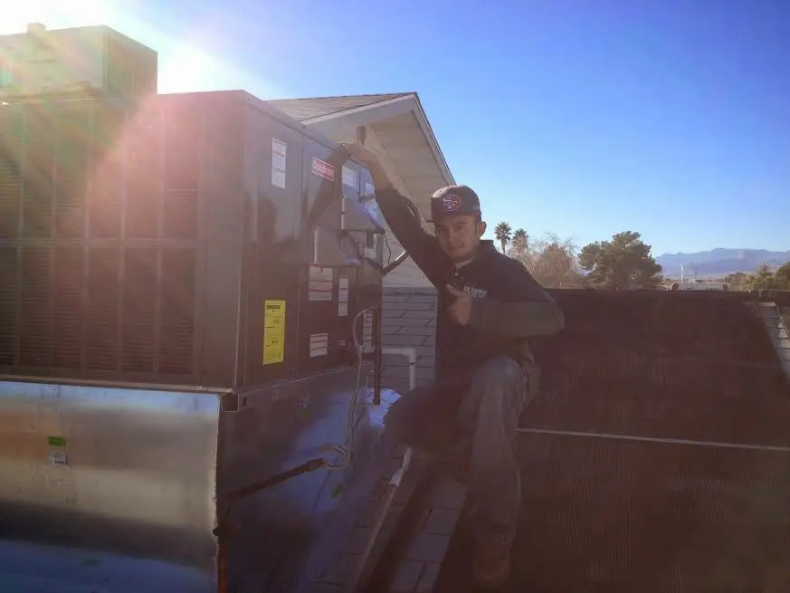 HVAC technician performing AC Tune-Up on a rooftop unit in Crestline